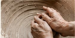 Hands shaping a ceramic piece